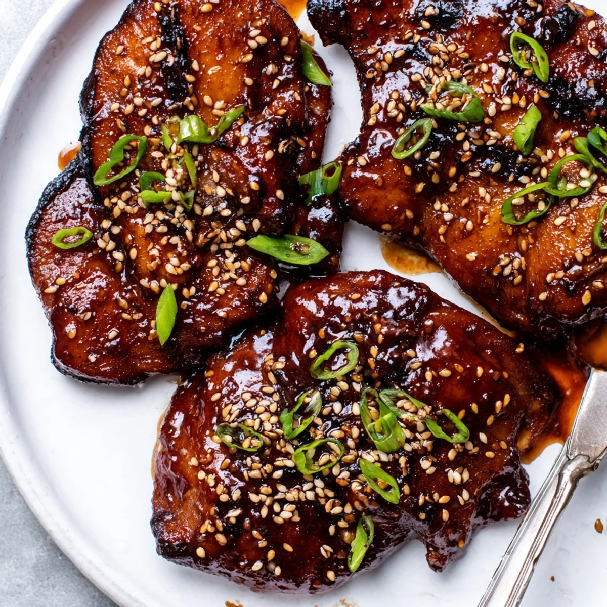 Juicy Korean Chicken Thighs glistening with sticky gochujang glaze, sprinkled sesame seeds.