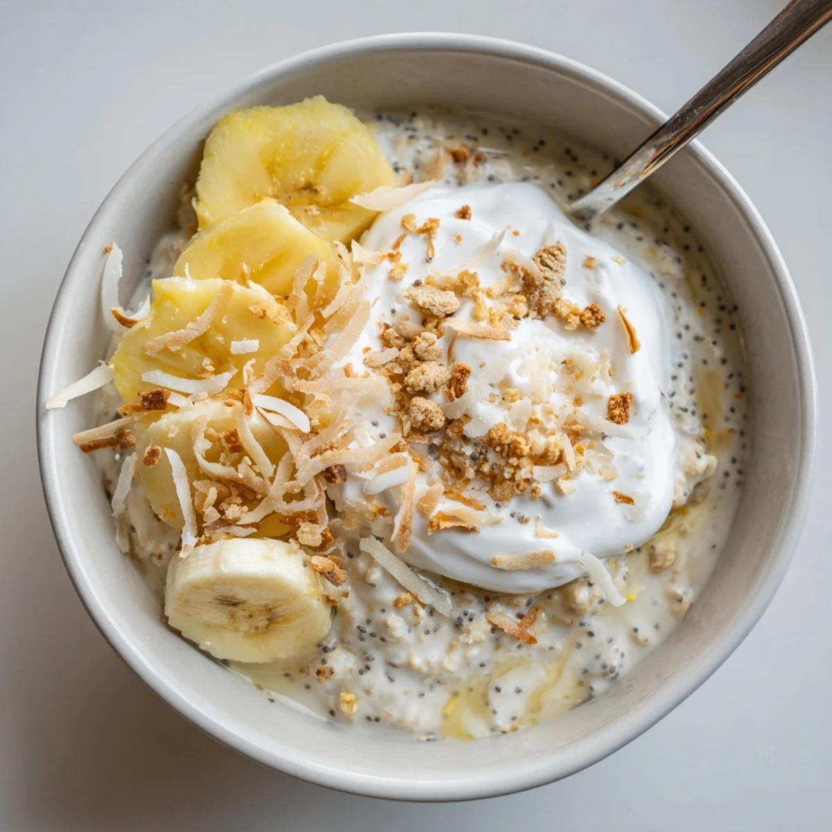 Coconut Cream Pie Overnight Oats topped with toasted coconut and banana  