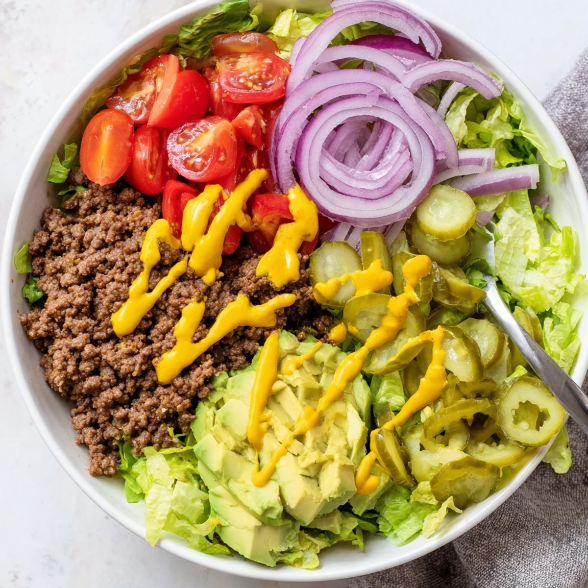 Bright salad-style Savory Protein Packed Burger Bowls drizzled with tangy burger sauce.