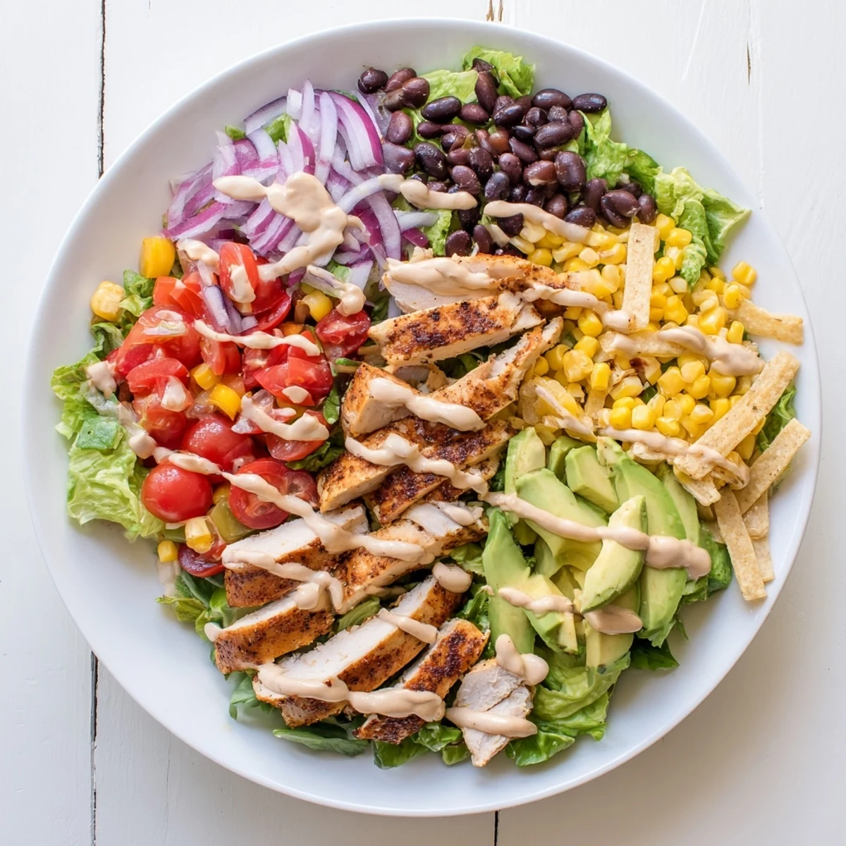 Vibrant Southwestern chicken salad plated with crisp romaine, juicy grilled chicken breast, colorful veggies, and zesty dressing