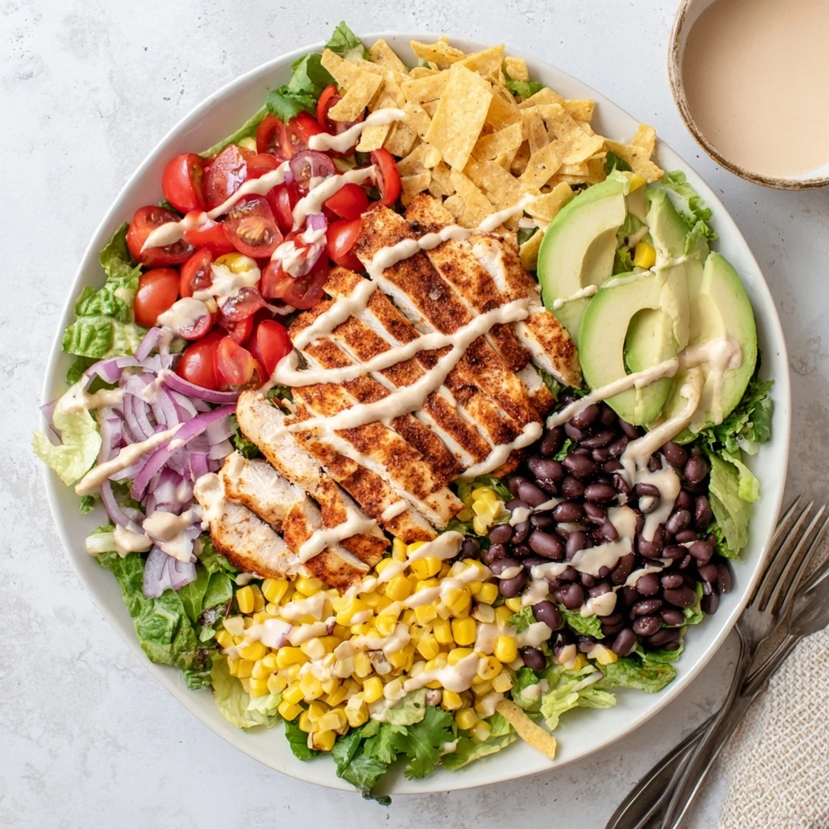 Hearty Southwestern chicken salad featuring spiced grilled chicken over mixed vegetables, beans, corn, and tangy yogurt dressing