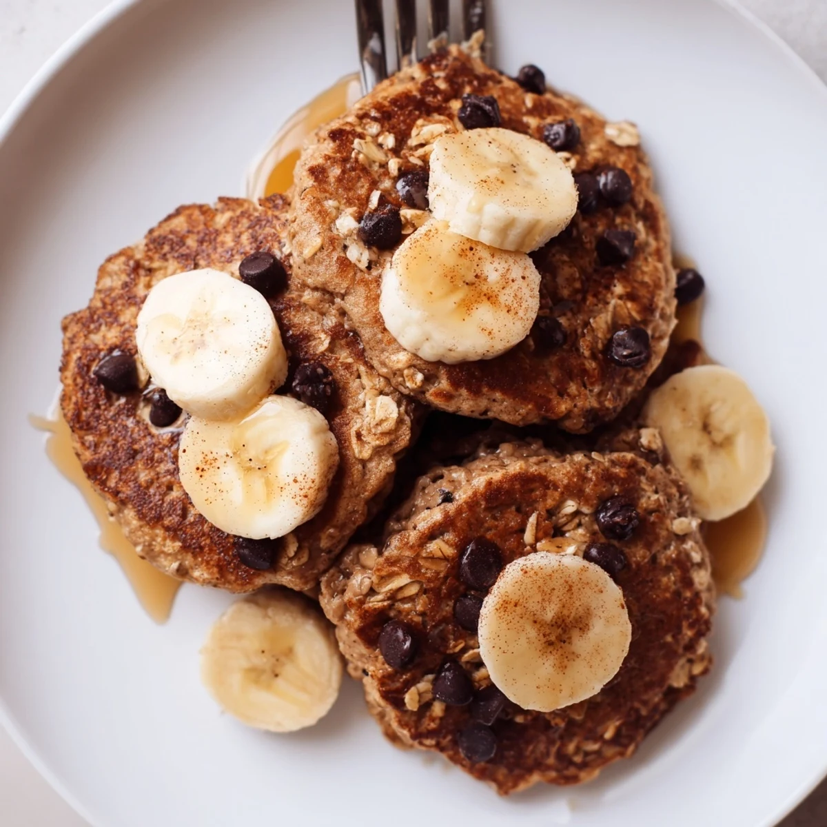 Stack of protein banana pancakes topped with berries and dusting of cinnamon