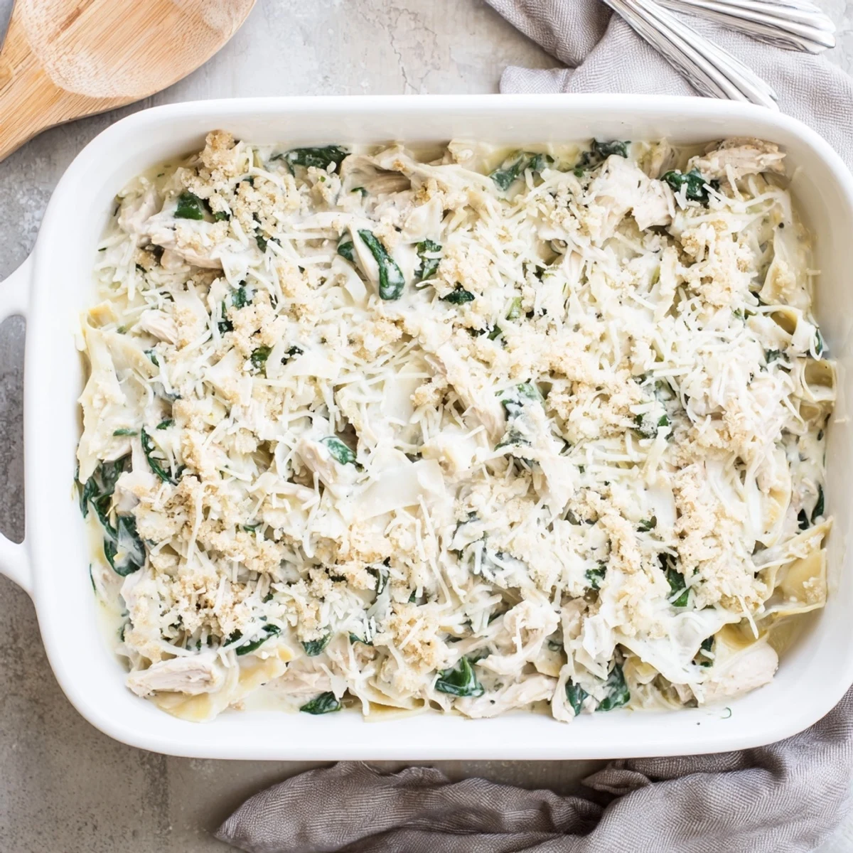 Creamy spinach artichoke chicken casserole fresh from the oven with tender shredded chicken