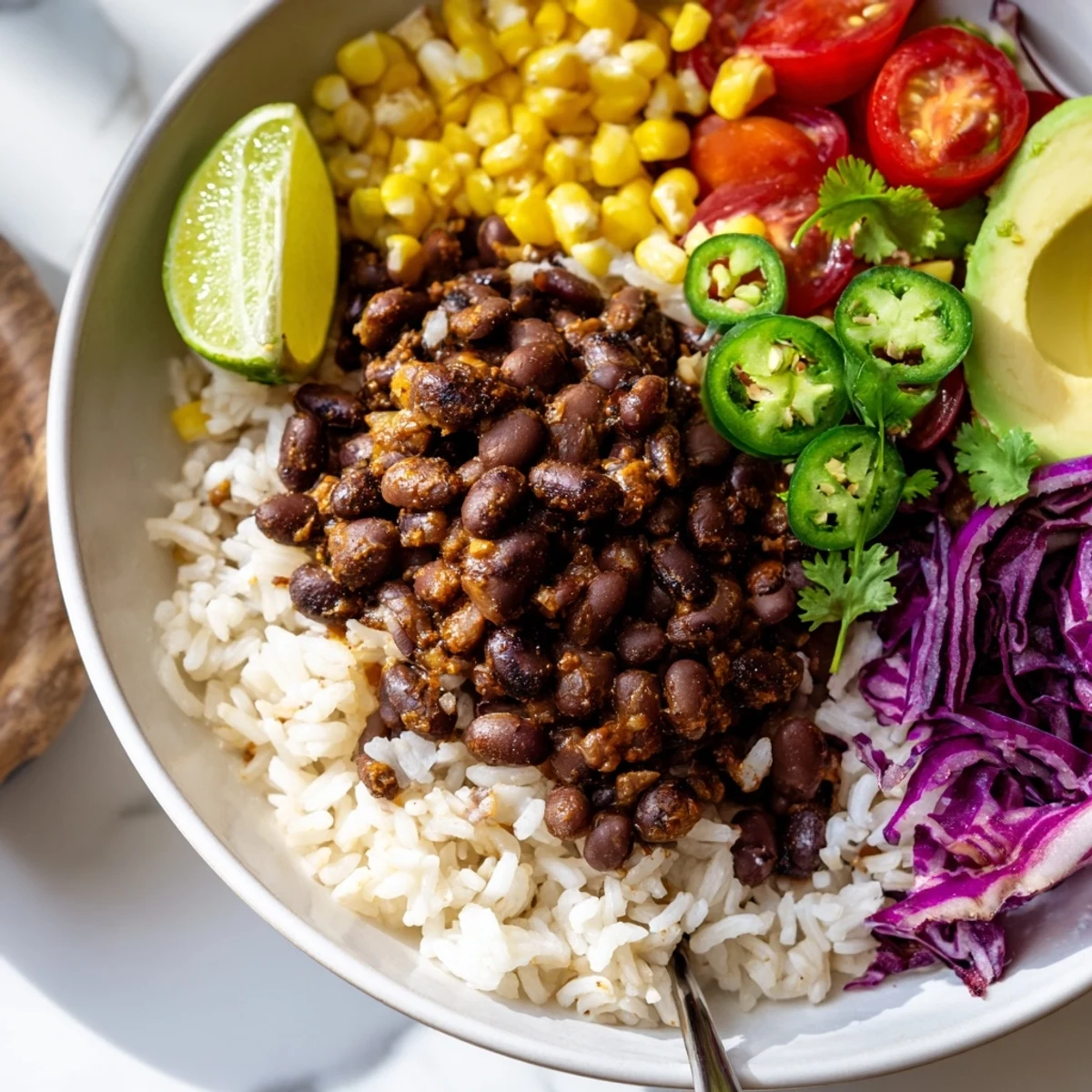 Hearty black bean and rice bowl topped with vibrant avocado and fresh cilantro