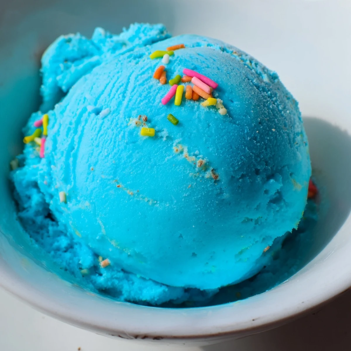 Creamy Blue Moon Ice Cream scooped into a crunchy waffle cone with colorful sprinkles