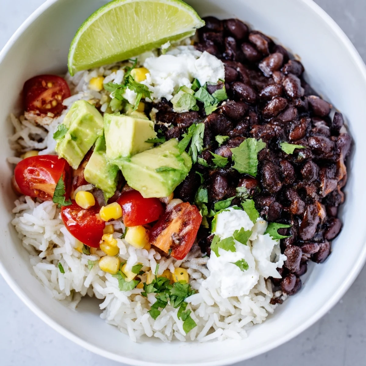 Smoky seasoned black bean and rice bowl served with creamy queso fresco and garnishes
