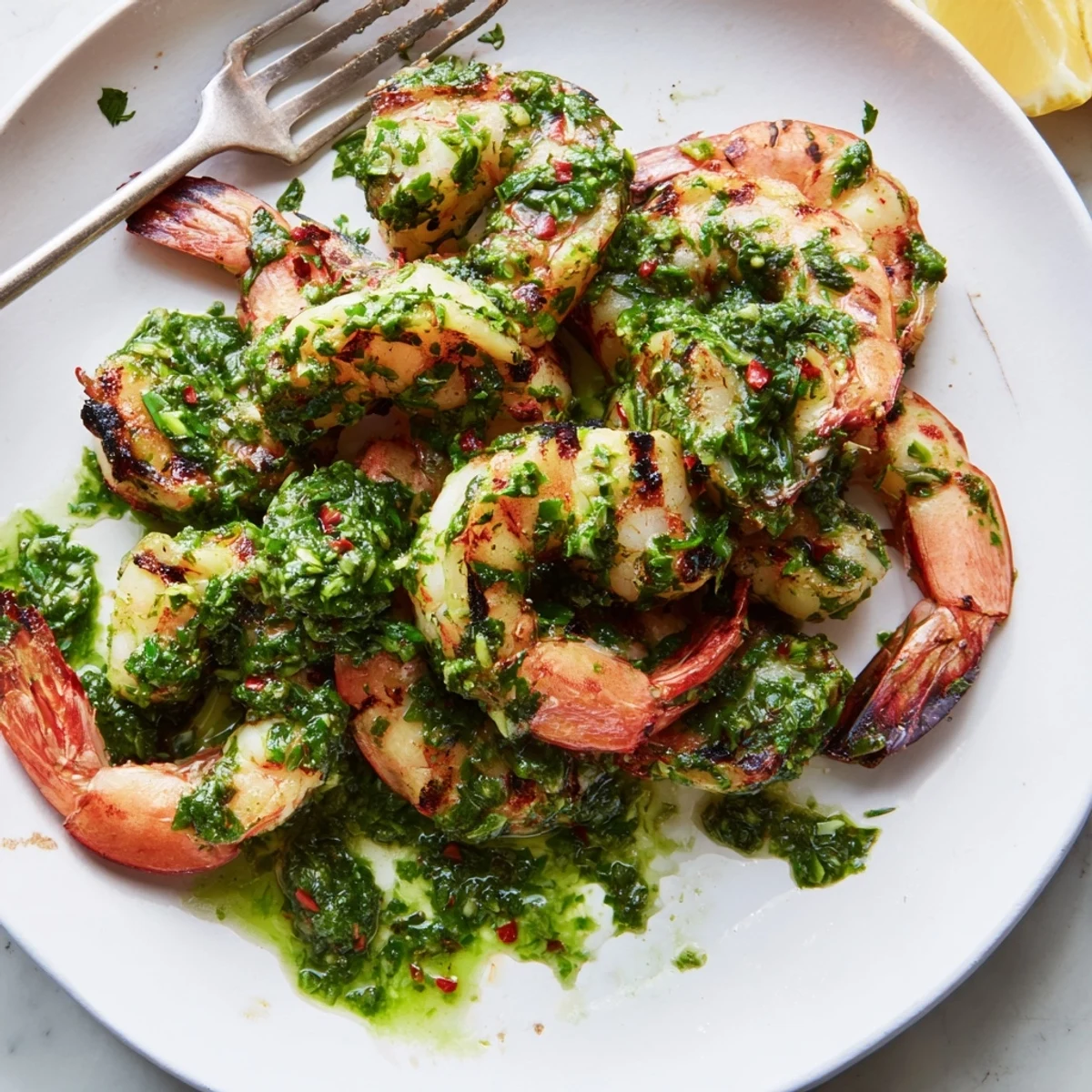 Plump chimichurri shrimp topped with fresh herbs and tangy lemon wedges