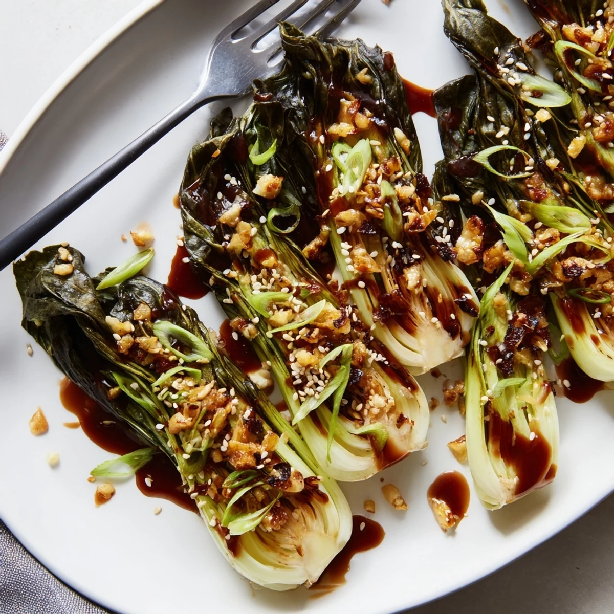Caramelized garlic bok choy glistening with sesame glaze on a white plate