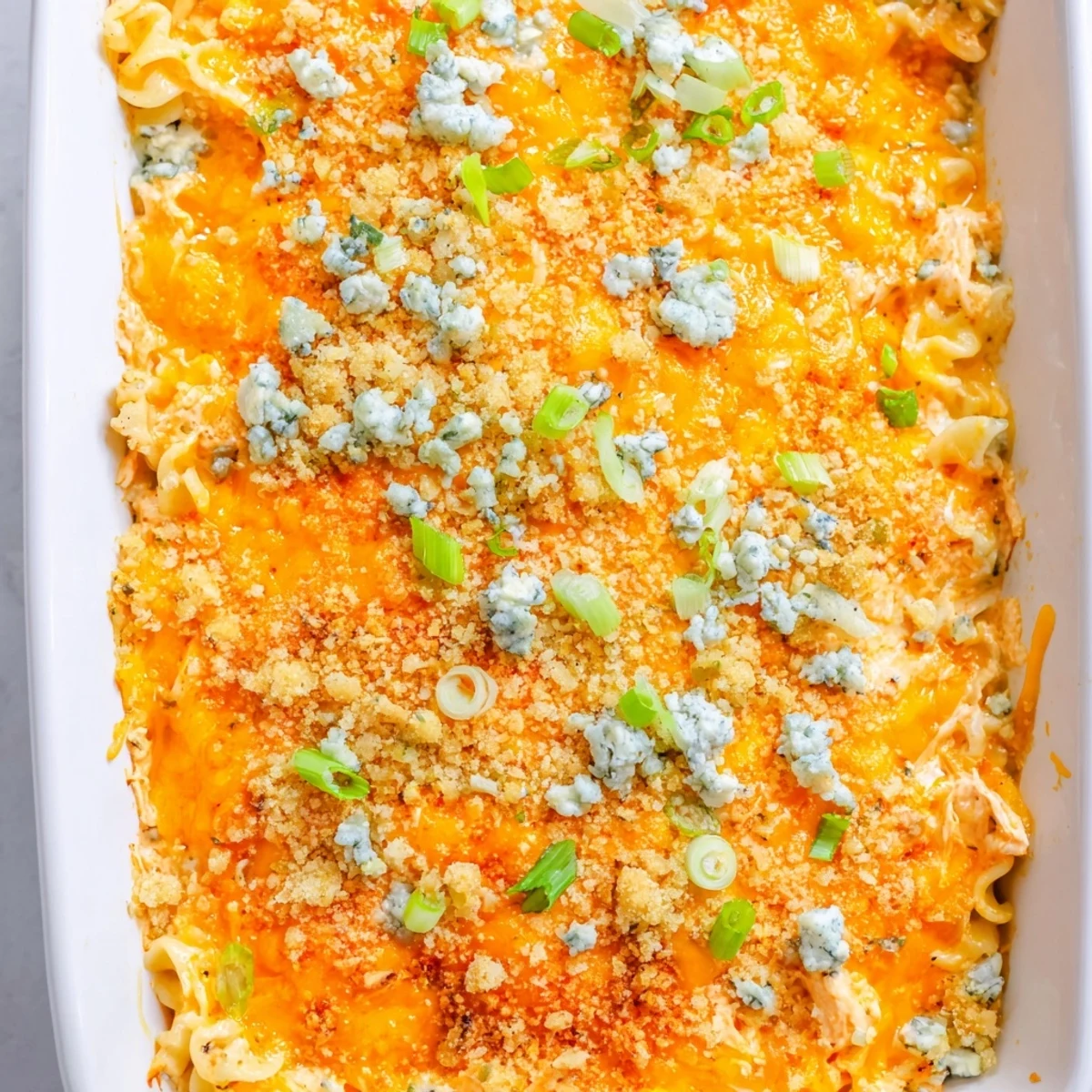 Steaming scoop of Cheesy Buffalo Chicken Dip Casserole served in a rustic white dish