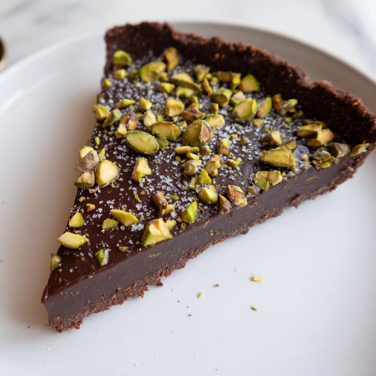 Dark Chocolate Pistachio Tart with glossy ganache and crunchy green pistachio topping