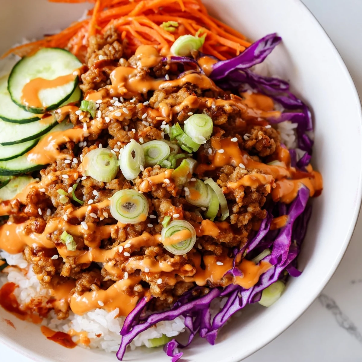 Ground Turkey Rice Bowls topped with colorful crisp vegetables and drizzled Bang Bang sauce