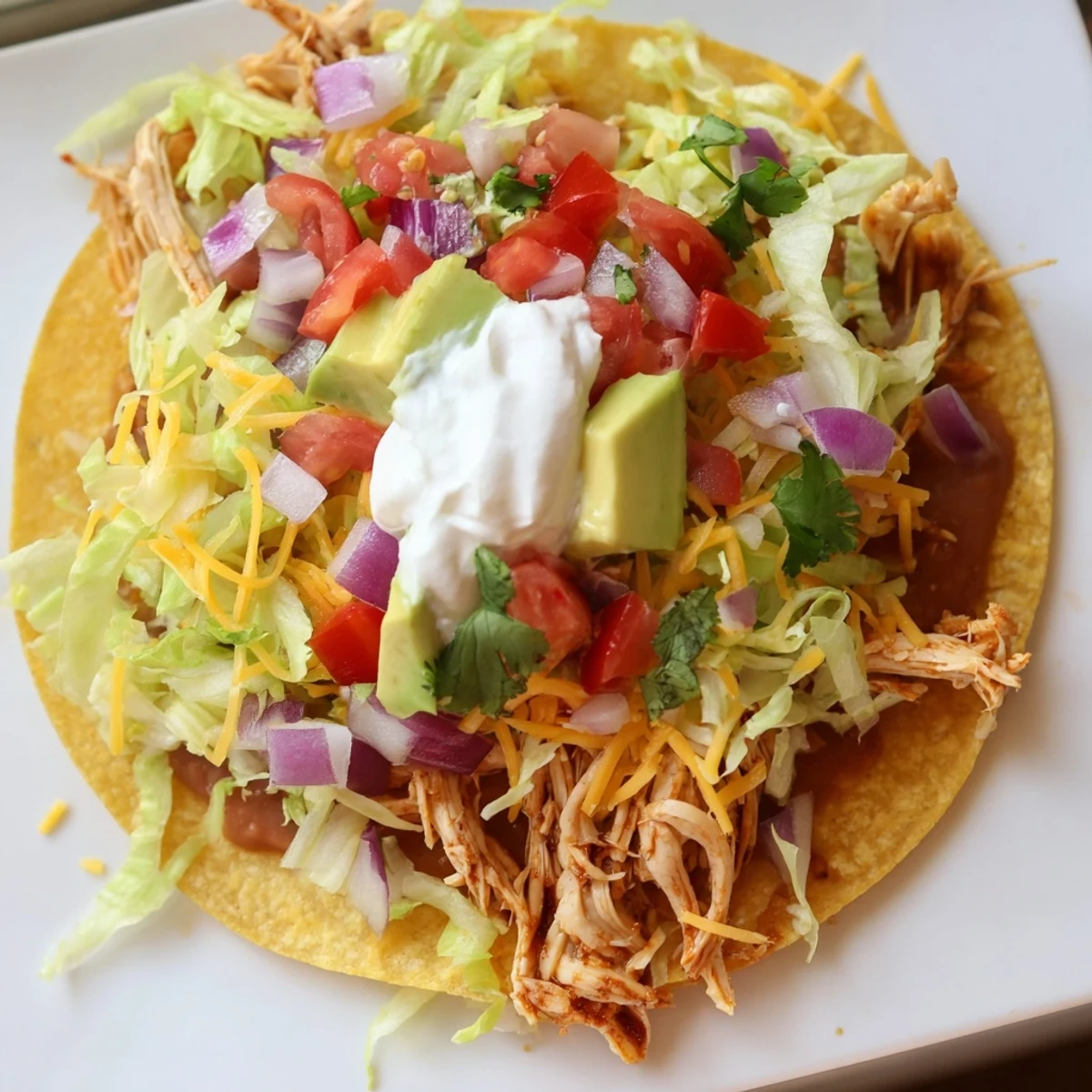Golden corn tortillas topped with seasoned chicken and colorful garnishes.