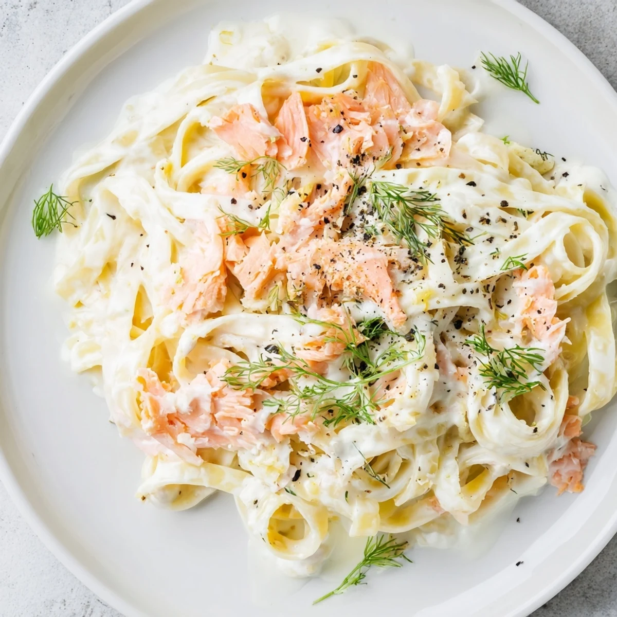 Twirling pasta strands coated in a velvety sauce with tender smoked salmon flakes