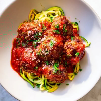Turkey Meatballs with Zucchini Noodles feature tender, herb-infused turkey balls in a chunky tomato sauce over light spiralized zucchini.